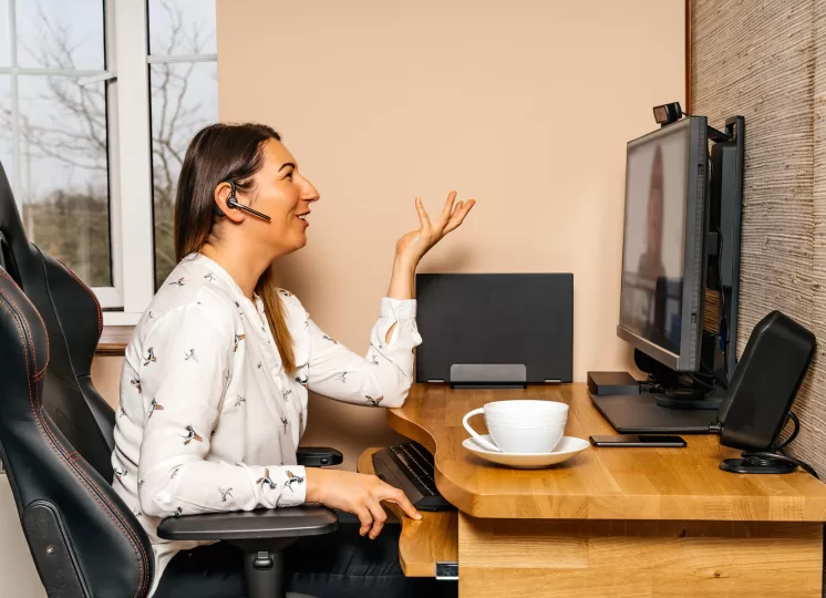 Mulher trabalhando em home office com isolamento acústico, participando de reunião online em ambiente silencioso.