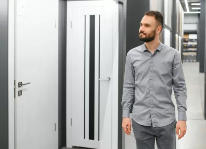 Homem observando modelos de portas acústicas em exposição.