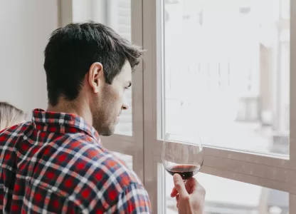 homem apreciando o silêncio ao olhar pela janela antirruído em casa