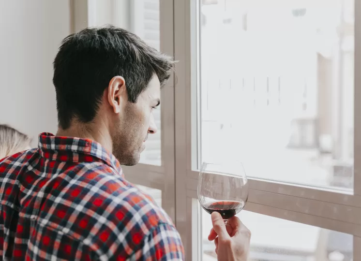 homem apreciando o silêncio ao olhar pela janela antirruído em casa