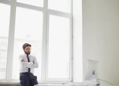 Homem em escritório moderno com grandes janelas antirruído para home office, transmitindo conforto e silêncio no ambiente de trabalho.